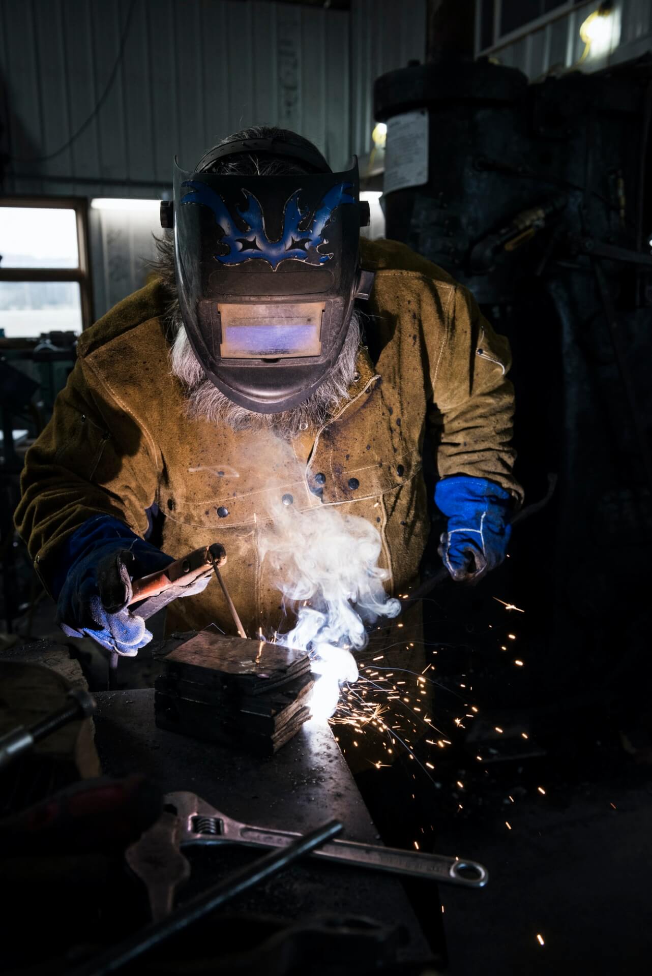 blacksmith-in-welding-mask-welding-metal-in-workshop.jpg